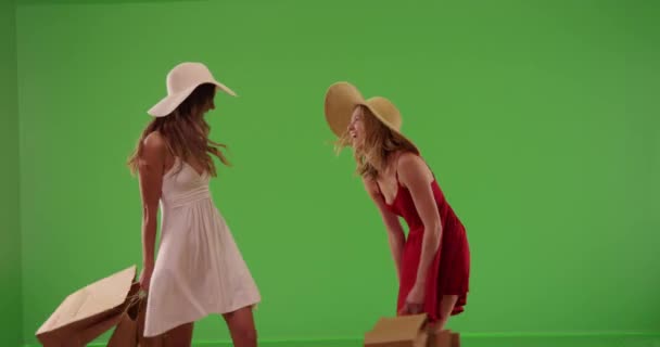 Two Young Attractive Girls Dresses Carrying Shopping Bags Spinning Greenscreen — Stock Video