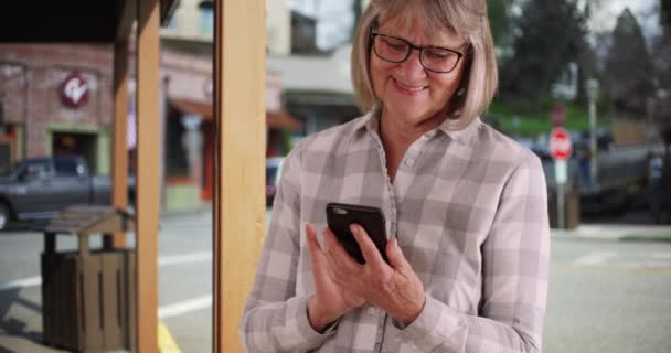 Χαρούμενη Ώριμη Κυρία Χρησιμοποιώντας Smartphone Για Στείλετε Κείμενο Που Στέκεται — Αρχείο Βίντεο