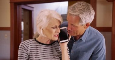 Evde akıllı telefondan konuşan son sınıf çifti. Yaşlı çift aileleriyle konuşmak için akıllı telefon kullanıyor. 4k