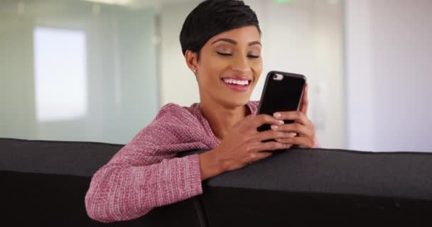 Modern Ofisteki Koltukta Oturan Çekici Siyahi Kadın Akıllı Telefondan Mesaj — Stok video