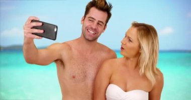Genç sosyal medya saplantılı çiftin internete koymak için selfie çekmesi. Mutlu genç milenyum çifti akıllı telefonuyla şirin fotoğraflar çekiyor. 4k