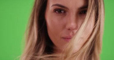 Yeşil ekranda kameraya bakan çekici milenyum kızının yakın çekimi. Anahtar ya da birleşik olmak üzere yeşil ekranda.