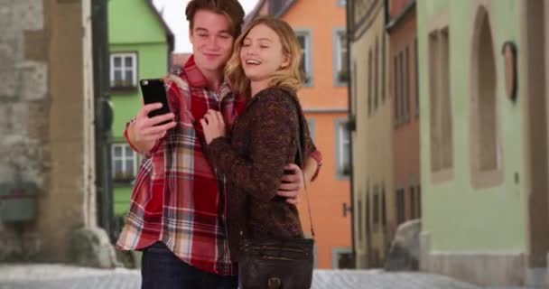 在欧洲度假的两对千年夫妇带着自己的手机一起去度假 迷人的男性和女性游客做傻脸 用智能手机拍照 微笑和大笑 — 图库视频影像