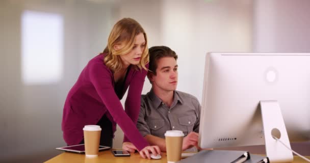 成功的女商人在男同事在办公大楼的电脑上工作时对他进行监督 从事项目 解决问题的男同事和女同事 — 图库视频影像