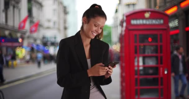 Улыбающаяся Деловая Женщина Лондонской Улице Красной Телефонной Будкой Переписывающаяся Смартфоном — стоковое видео