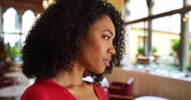 年轻的黑人女士陷入沉思中 转身面对着餐馆里的摄像机 随意的非裔美国千禧年女孩转向餐馆里的相机 — 图库视频影像