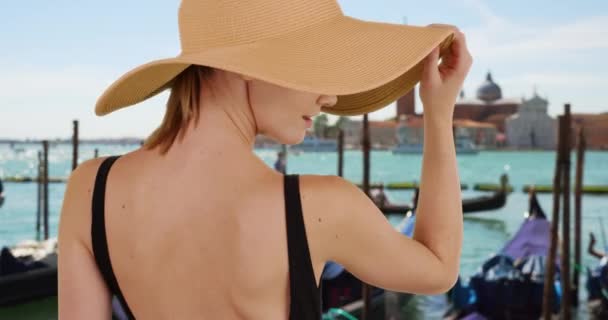 威尼斯时尚的白人女孩戴着一顶软软的太阳帽 后见大运河边的女游客面带微笑 — 图库视频影像