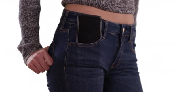 年轻女性腰围与手机在前面口袋的白色复制空间 近中段的女孩穿着蓝色牛仔裤 口袋里的手机白色背景 — 图库视频影像