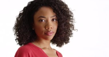 Beyaz arka planda nazik gülümsemesi olan çekici siyah bir kadına yakın durun. Stüdyoda kameraya gülümseyen güzel Afrikalı kadın portresi. 4k