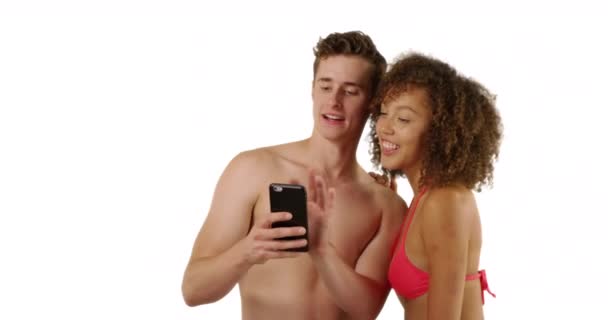 一对快乐的多种族夫妇在沙滩上拍了一张照片 背景是白色的 有版权 千禧年的男男女女在带复制空间的工作室里用智能手机自拍 — 图库视频影像
