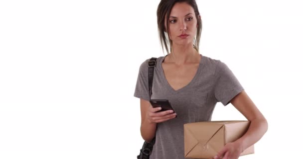 Kvinna Som Använder Mobiltelefon Medan Håller Postpaket Fast Vit Bakgrund — Stockvideo