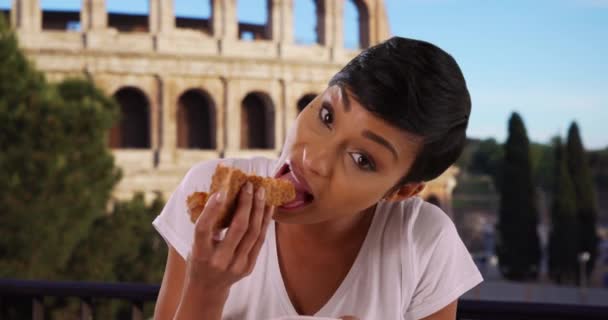イタリアのローマでピザを食べるアフリカ系アメリカ人女性観光客の肖像画を閉じます 休暇中の陽気で笑顔の若い黒人女性は ピザのおいしいスライスを楽しんでいます — ストック動画
