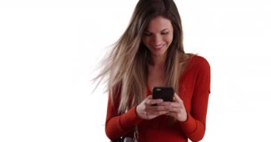 Milenyum kadını akıllı telefondan mesaj atıyor ve beyaz fotokopi alanında mutlu görünüyor. 20 'li yaşlarda beyaz bir kız telefonda beyaz arka planda mutlu mesut mesajlaşıyor. 4k