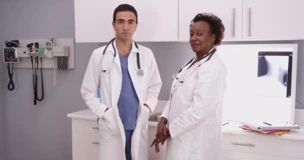 Dva Doktoři Ordinaci Bílé Uniformě Dívají Kamery Mladý Hispánský Radiolog — Stock video