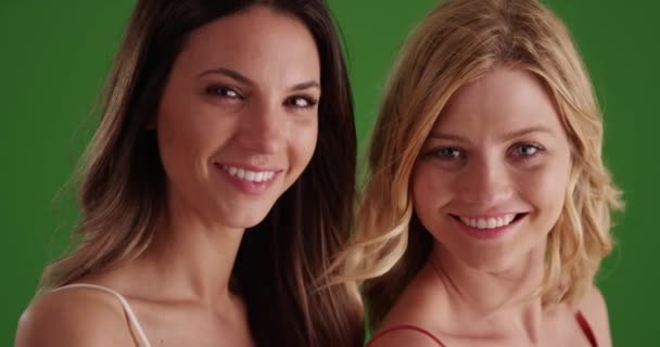 两个漂亮的女人 笑得大大的 摆出一副绿色的样子 可爱的高加索女孩的画像 对着镜头微笑 准备好了绿色铬色的作曲 — 图库视频影像