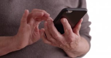 Yetişkin bir kadının beyaz fotokopi alanındaki mesajları okumak için akıllı telefon kullanması. Üst düzey birinin beyaz arka planda cep telefonuyla mesajlaşırken çekilmiş sıkı bir fotoğrafı. 4k