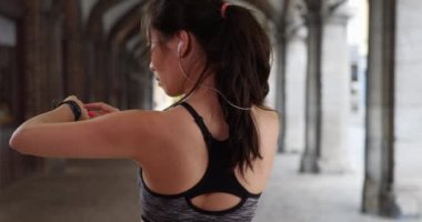 Atletik milenyum kadını Avrupa 'nın akıllı adamlarıyla ilgili gelişmeleri kontrol ediyor. Şehir ortamında kalp atışlarını izlemek için kol saatine bakan sportif bayan koşucu. 4k