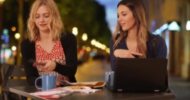 Güzel sarışın kadın Fransa 'nın başkenti Paris' teki Şanzelize 'ye gitmek için arkadaşıyla akıllı telefon kullanıyor. Fransız alışveriş bölgesinde oturan ve akıllı telefon kullanan sevimli gezgin kadınlar. 4k