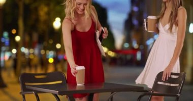 İki çekici genç kadın Champs Elysees Paris 'te akıllı telefon görüntülerini paylaşmak için bir araya geliyor. Paris, Fransa 'da yaz elbisesi giymiş bir çift güzel bayan. 4k