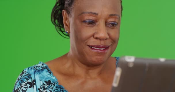 一位老年非洲裔美国妇女在绿色屏幕上使用她的平板电脑 在绿色屏幕上键入或合成 — 图库视频影像