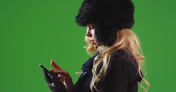 白种人女人戴着帽子和围巾发短信在绿色屏幕上等人 在绿色屏幕上键入或合成 — 图库视频影像