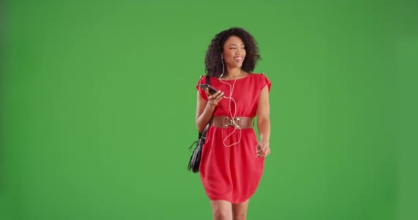 Yeşil Ekran Arka Planında Yürüyen Akıllı Telefon Müziği Dinleyen Mutlu — Stok video