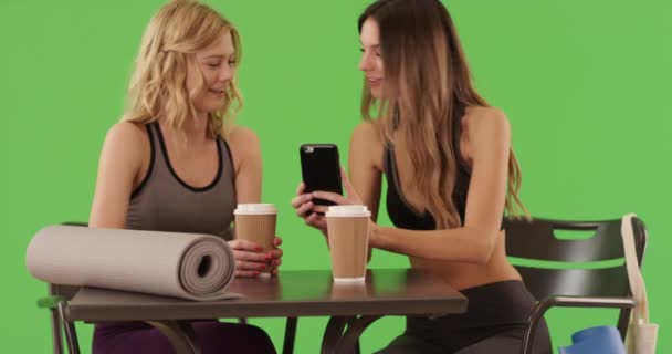 让年轻女性坐在瑜伽垫上 并在绿色屏幕上自拍 健康迷人的女孩穿着运动服坐在那里 用智能手机在绿屏上自慰 — 图库视频影像