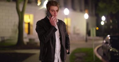 Çekici beyaz bir erkek cep telefonuyla konuşuyor. Akşamları kampüs binasının önünde taksi çağırıyor. Deri ceketli beyaz bir erkek öğrenci telefon görüşmesi yapıyor, gece dışarı çıkmayı bekliyor. 4k