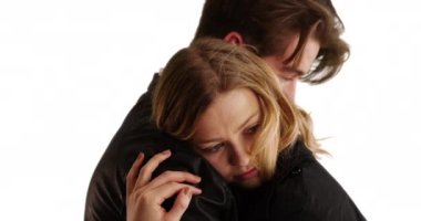 Beyaz arka planda şefkatle kucaklaşan genç erkek ve dişiye yaklaş. Stüdyoda erkek arkadaşına sarılmış gülümseyen içerikli bir kadının yakın çekimi. 4k