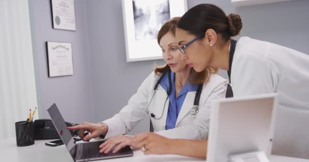 의사가 노트북 컴퓨터에서 환자의 결과를 기사보기 의사가 동료와 컴퓨터 스캔에 — 비디오