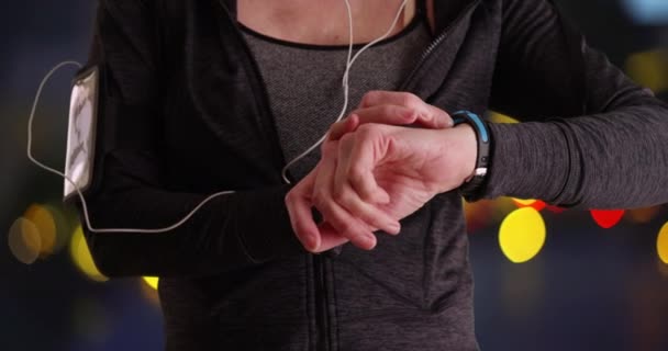 Zbliżenie Dojrzałej Biegaczki Pomocą Smartwatcha Biegacz Słuchawkami Pomocą Czujnika Aktywności — Wideo stockowe
