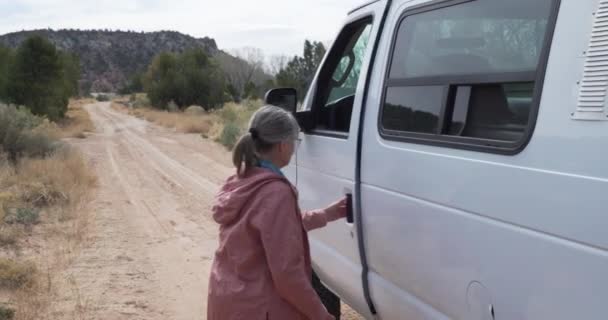 Adventurous Senior Woman Stepping Large Van Driving Away Dirt Trail — Stock Video