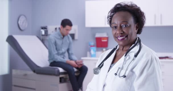 Portret Starszej Czarnej Lekarki Uśmiechającej Się Kamery Pacjentem Tle Zbliżenie — Wideo stockowe