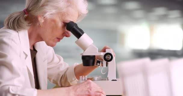 Naukowiec Białym Fartuchu Laboratoryjnym Badający Substancję Pomocą Mikroskopu Dojrzała Kobieta — Wideo stockowe