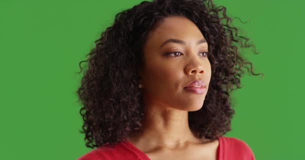 緑の画面の背景に横に賢く見えるかなり黒い女性のクローズアップ キーや合成のための緑の画面上の生活についての魅力的なアフリカ系アメリカ人の千年紀の思考 — ストック動画