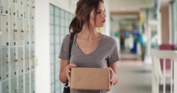 小包で住所を読み 郵便局ホールのロッカーで画面を歩く女性 郵便局で郵便局に向かう前に 白人の少女が荷物をチェックしています — ストック動画