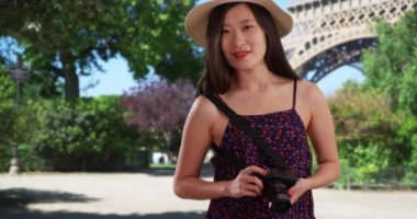Paris Fransa 'da Eyfel Kulesi' nin önünde fotoğraf çeken genç ve tatlı bir fotoğrafçı. Binlerce yıllık turistin Avrupa 'da DSR kamerasıyla fotoğraf çekimini yakından izleyin. 4k
