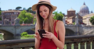 Şapkalı ve kolsuz tişörtlü mutlu bir milenyum kadını Roma 'da tatildeyken telefon uygulaması kullanıyor. 20 'li yaşlarda hippi bir kız İtalya, Roma' dayken akıllı telefondan mesaj atıyor. 4k