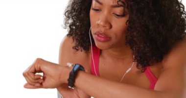 Beyaz arka planda akıllı adam kullanan sert siyah kadın koşucuyu yakından çek. Stüdyoda nefes nefese kalan güzel Afro-Amerikan kadınlarını yakından çek. Akıllı saatlerini kullan. 4k