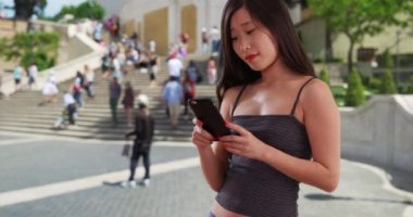 Roma 'daki İspanyol Merdivenleri' ndeki mesajları okumak için akıllı telefon kullanan güzel milenyum kadınlarına yakın çekim. Avrupa 'da cep telefonu mesajlarına bakan genç bir Asyalı kadın. 4k