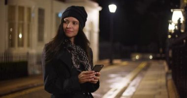 Güzel beyaz kız dışarıda akıllı telefonuyla mesajlaşıyordu. Geceleri dışarıda cep telefonunu kullanan bir kadın var. 4k