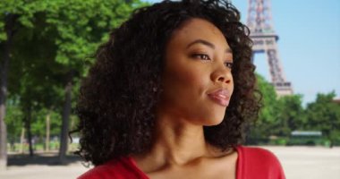 Paris 'te seyahat ederken rahatlamış genç Afrikalı bir kadın atmosferin tadını çıkarıyor. Paris, Fransa 'daki Eyfel Kulesi' nin yanında barışçıl görünümlü Afro-Amerikalı bir kadın. 4k