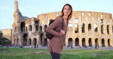 Roma 'yı gezen beyaz bir kadın. Sırt çantalı kadın turist tarihi Coliseum 'u ziyaret ediyor. 4k