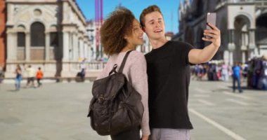 Mutlu ve çekici çift St. Mark Meydanı 'nda fotoğraf çekiyor. Milenyum erkeği ve dişisi Venedik 'te selfie çekiyor. 4k