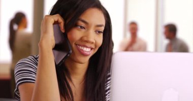 İş kadını ofisteki dizüstü bilgisayarla ilgili bilgi işlem departmanından yardım istiyor. Siyahi bir kadının akıllı telefonuyla bilgisayar sorunları hakkında konuştuğu yakın plan. 4k