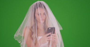 Gelin, yeşil ekranda akıllı telefonuna mesaj atmak için bir dakikasını ayırıyor. Anahtar ya da birleşik olmak üzere yeşil ekranda.