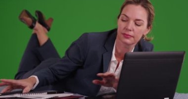 İş kadını karın üstü yatıp yeşil ekranda telefona cevap veriyor. Anahtar ya da birleşik olmak üzere yeşil ekranda.