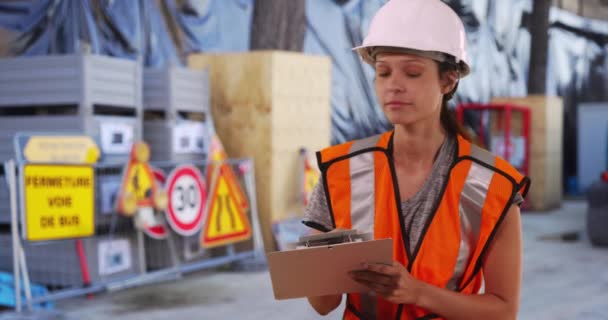 Mulher Trabalhadora Construção Capacete Colete Segurança Escrevendo Área Transferência Local — Vídeo de Stock