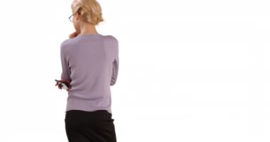 Kafkasyalı iş kadınının telif alanıyla stüdyoya bakınışının arka görüntüsü. Kadın CEO beyaz arka planda kameraya doğru fotokopi alanı ile duruyor. 4k