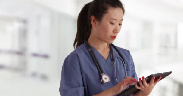 Werkende Duizendjarige Verpleegkundige Gekleed Scrubs Met Behulp Van Handheld Tablet — Stockvideo